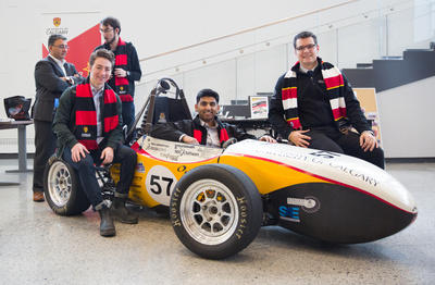 Schulich Racing team members show off their vehicle for guests as part of a student showcase at the official opening of the new Canadian Natural Resources Limited Engineering Complex.