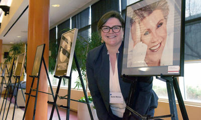 Annie Murray is head of Archives and Special Collections, which manages the EMI Music Canada Archive. She stands next to an image of Canadian singer Anne Murray on display at the announcement of the donation to the University of Calgary. 
