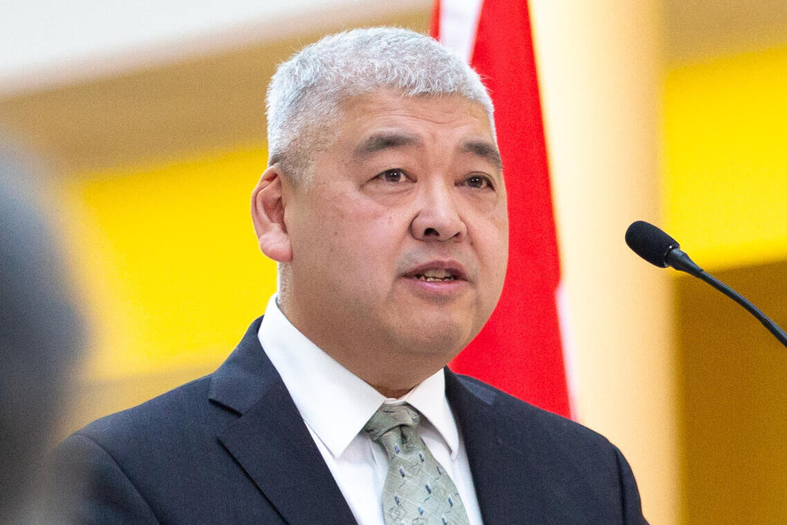 A man stands in front of a microphone