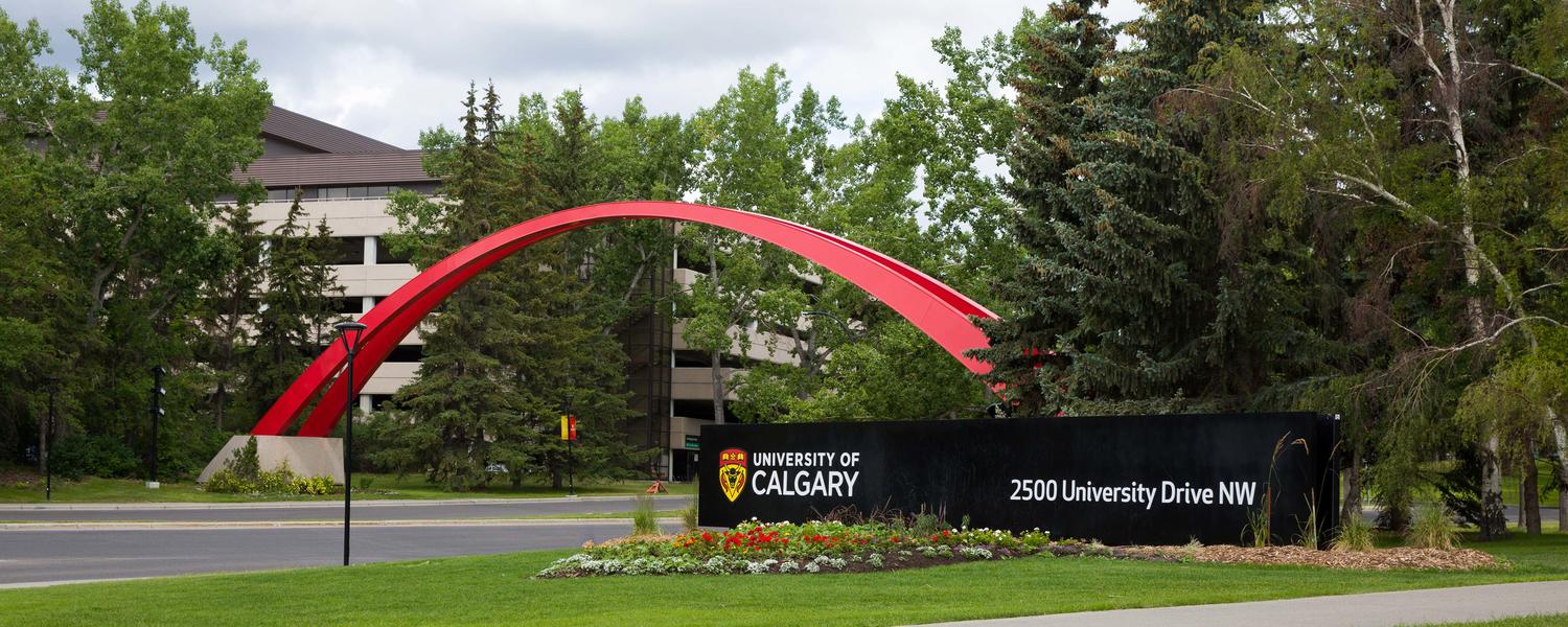 UCalgary main entrance to parking lot 1 and bus loop. Red arch, University of Calgary address on black sign