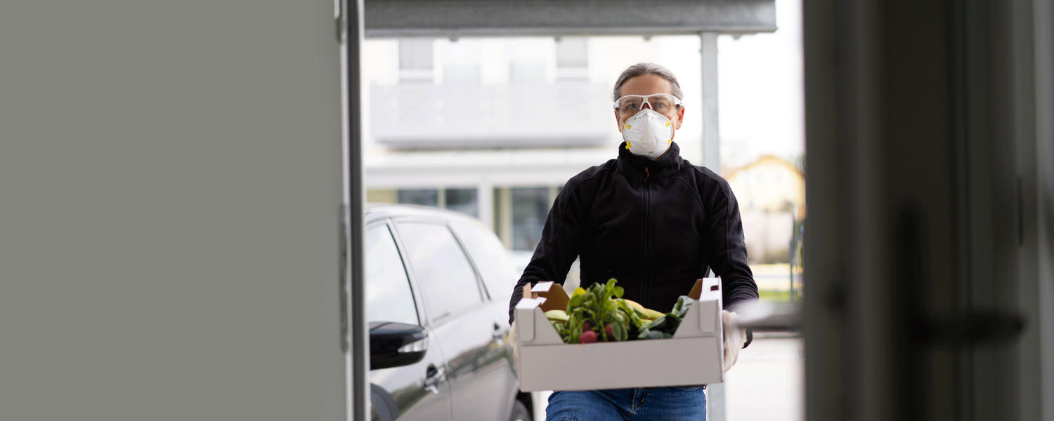 man wearing mask volunteers with grocery delivery