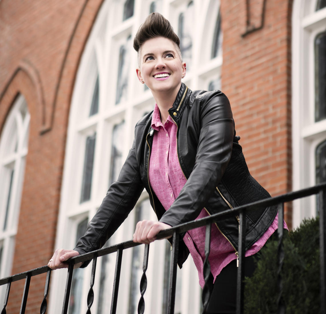 Woman with short dark hair smiles in front of a church