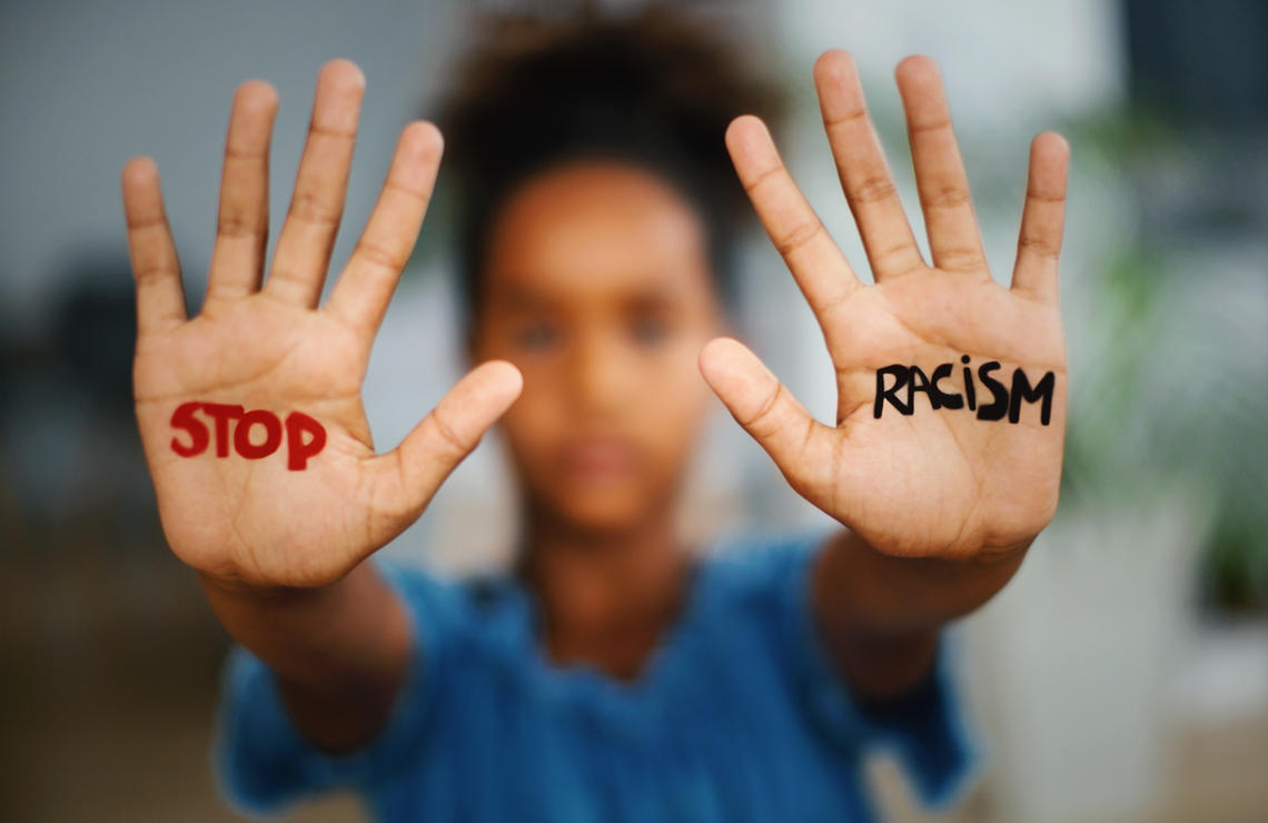 Girl with written text on hands: STOP RACISM