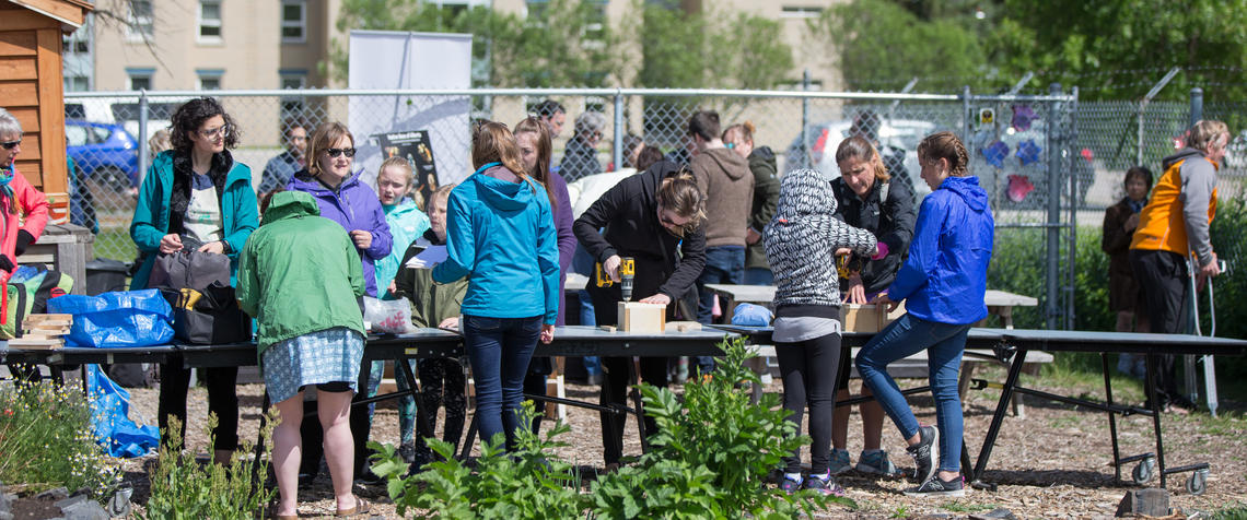 Group of people work around a table in the community garden