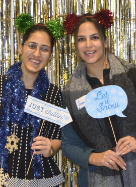 Two students pose in a festive photo booth. 
