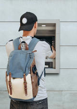 man standing at an ATM