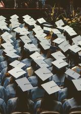 people sitting at a convocation ceremony wearing graduation caps
