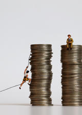 Two stacks of coins with a small figurine sitting on one. On the other, a small figure is climbing a rope to the top.