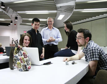 students looking at a laptop - Image courtesy University of Calgary