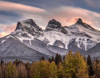 Sunset light just hitting the top of the Three Sister peaks near Canmore, Alberta, Canada