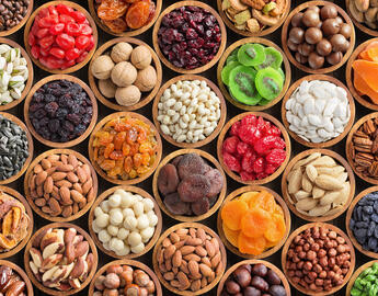 mixed nuts and dried fruits in bowls, top view. healthy snack for vegetarian, food background.