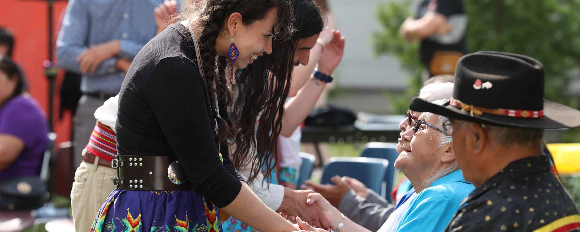 Elder Florance Kelly shakes hand with UCalgary student, Kiara Johnson from Maskwacis.