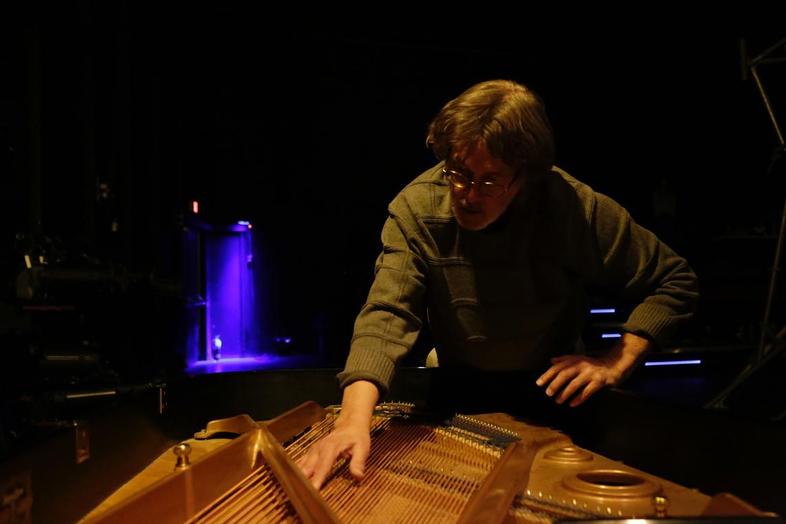Music professor Allan Bell plays a piano from inside its body in a scene from Conduct, running Feb. 9-17 at the Reeve Theatre. 