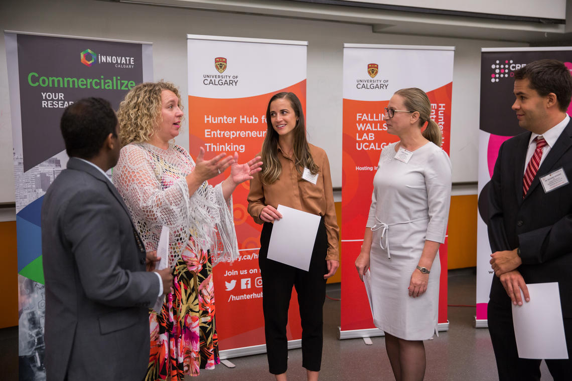 Joelle Foster, left, executive director of the Hunter Hub for Entrepreneurial Thinking, speaks with Falling Walls competitors.