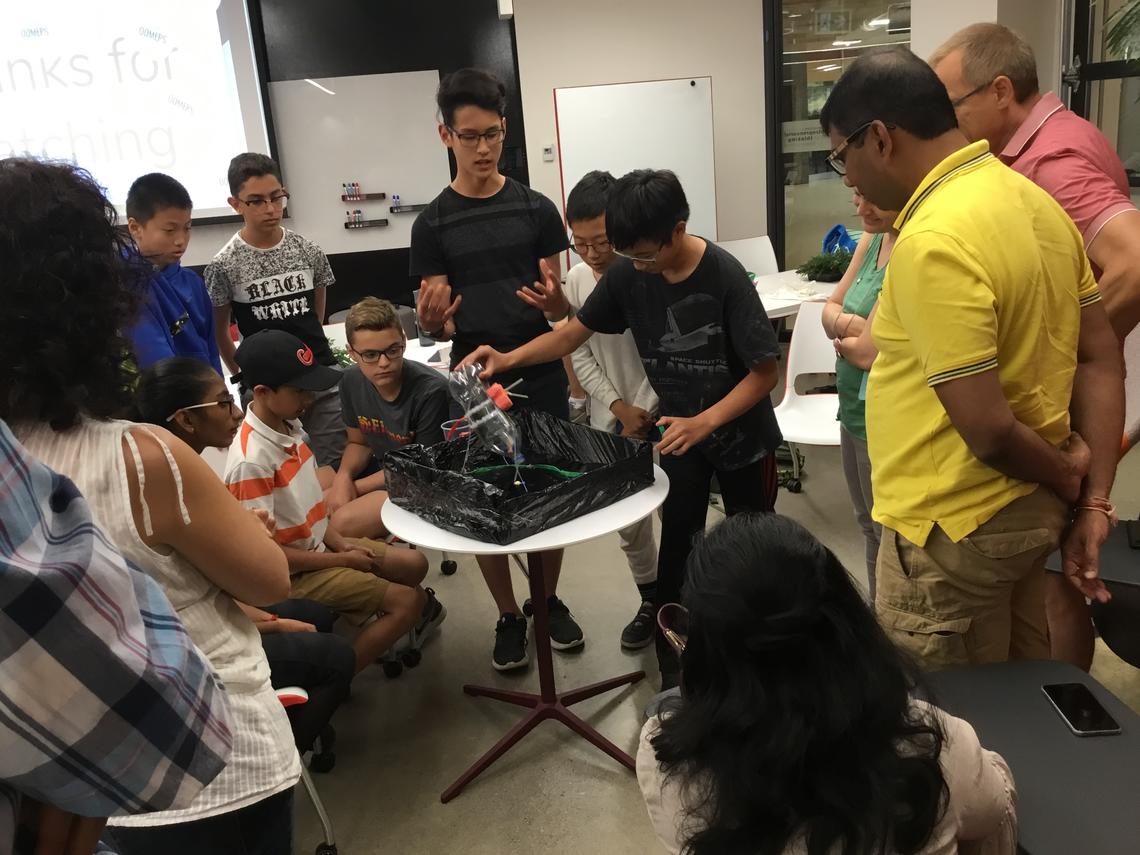 At the end of Young Entrepreneurs camp, participants show their entrepreneurial ideas to an audience of parents. This group, OOMEPS, are demonstrating their solution to clean up oil spills the moment they happen.