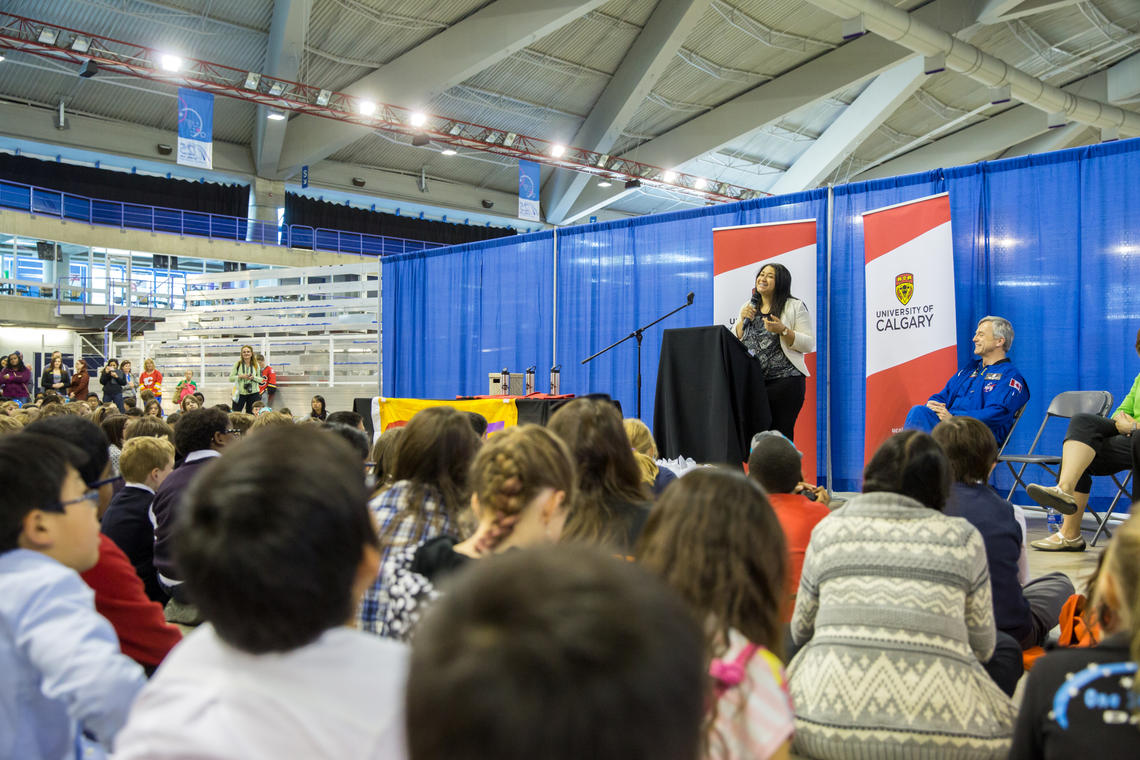 Amanda Black, a PhD student in the Faculty of Kinesiology, and University of Calgary Chancellor Robert Thirsk speak to students at the Calgary Youth Science Fair.