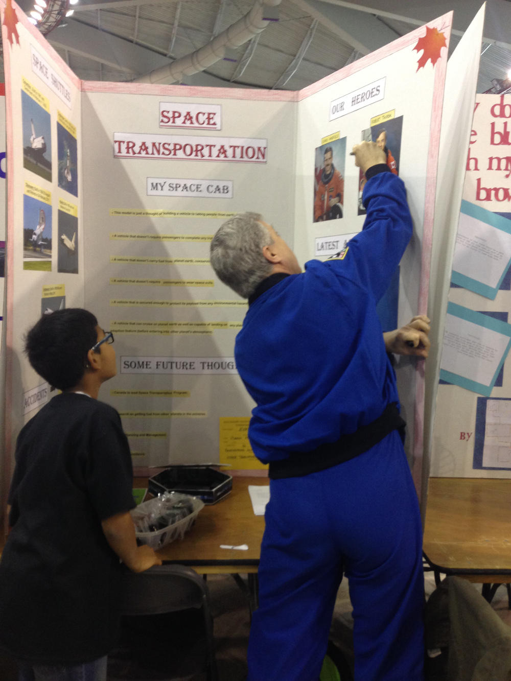 Chancellor Thirsk writes a personal message to a young science fair participant, whose project was on space transportation. The young boy had a photo of Thirsk with the title “Our Heroes” on his project. 