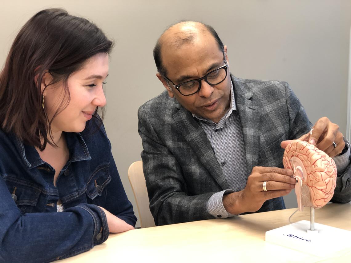 Dr. Raj Ramasubbu shows Beth MacKay where the stimulation device is place in the brain. 