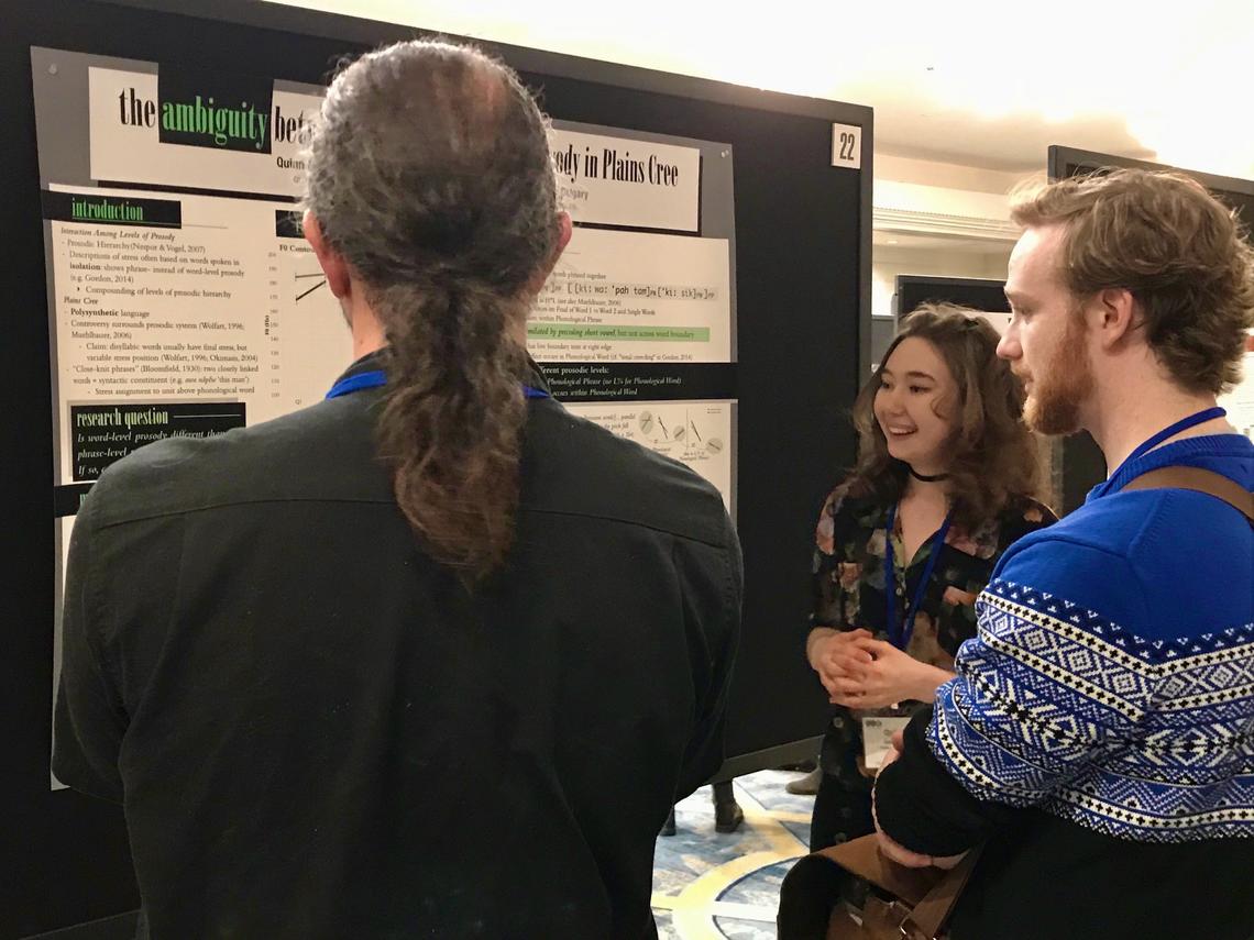 Graduating linguistics student Quinn Goddard, centre background, with a presentation at the Linguistics Society of America Conference in New Orleans this year with a poster entitled "The Ambiguity Between Lexical and Phrasal Prosody in Plains Cree.”
