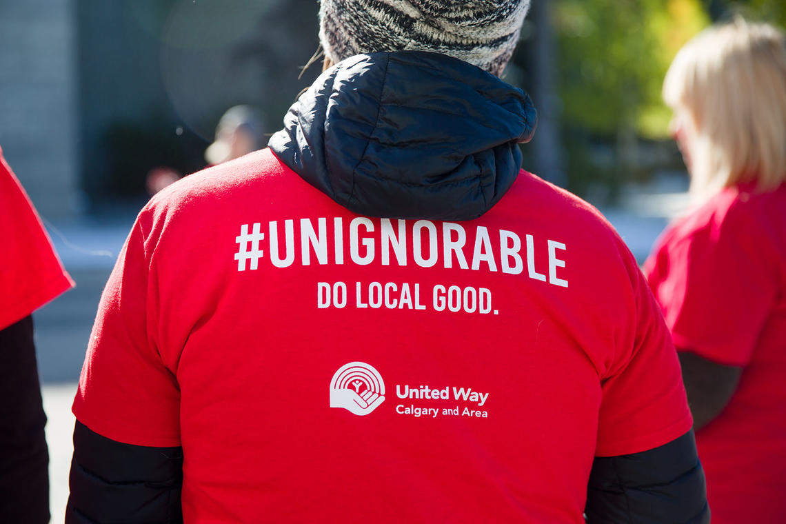 Image of a person's back and their shirt says "#unignorable" Do local good."