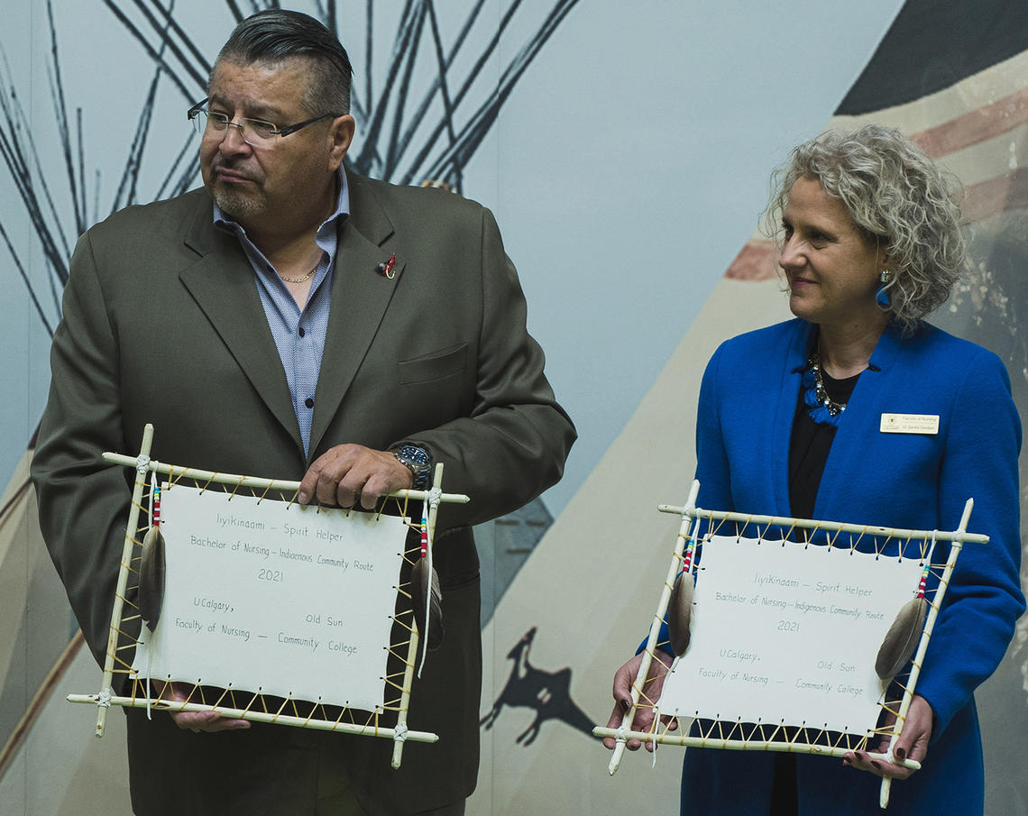UCalgary Faculty of Nursing Dean Sandra Davidson and Old Sun College President Maurice Manyfingers receive hand-written parchments celebrating the two institutions’ partnership. 