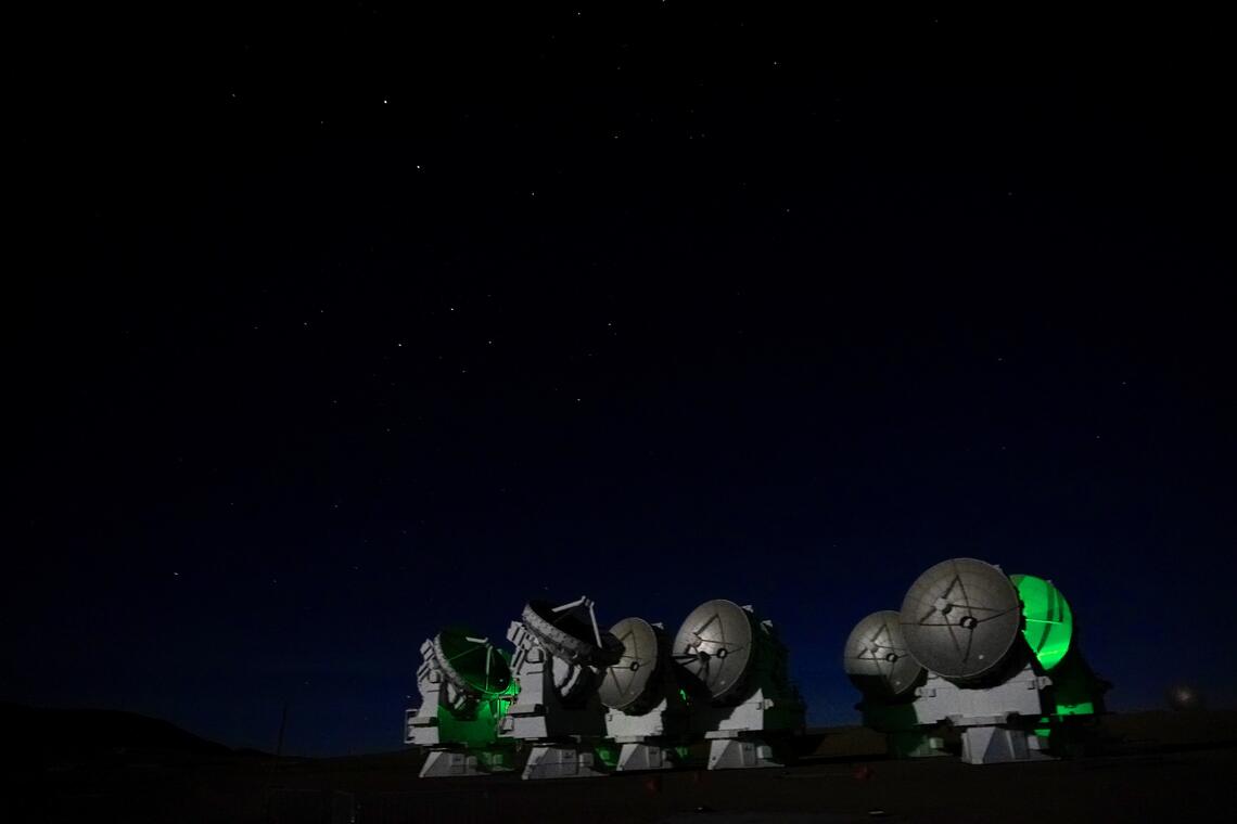 The ALMA telescopes at night.