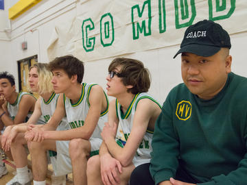 A basketball team sitting on a bench