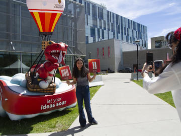 A UCalgary community member poses in front of the Stampede float during  the President's Stampede BBQ on July 12. 