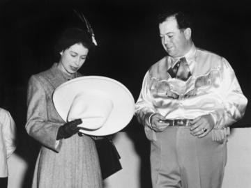 Princess Elizabeth looks at white cowboy hat owned by Mayor Don Mackay at the Stampede Corral, Calgary, Alberta