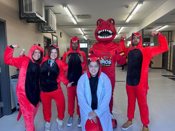 Kristi-Anne poses with Rex and fellow SU members wearing dino costumes