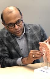 Dr. Raj Ramasubbu shows Beth MacKay where the stimulation device is place in the brain. 