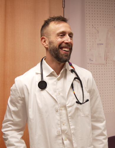 Dr. Caley Shukalek smiles in his white coat and stethoscope