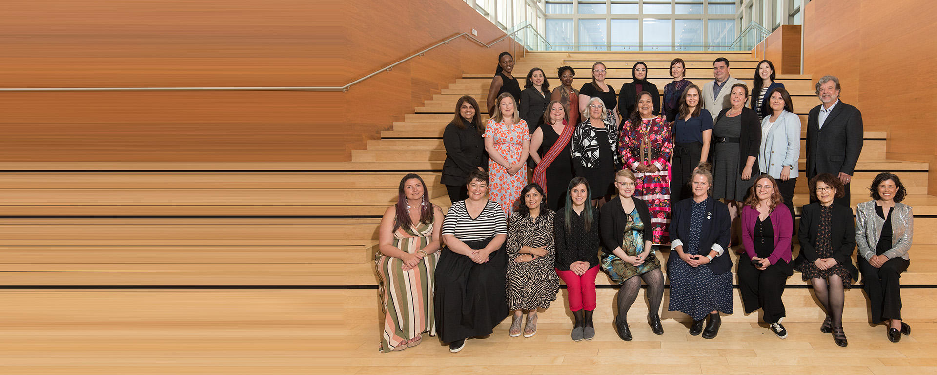 Members of the Teaching Academy standing on the stairs in the Taylor Institute building