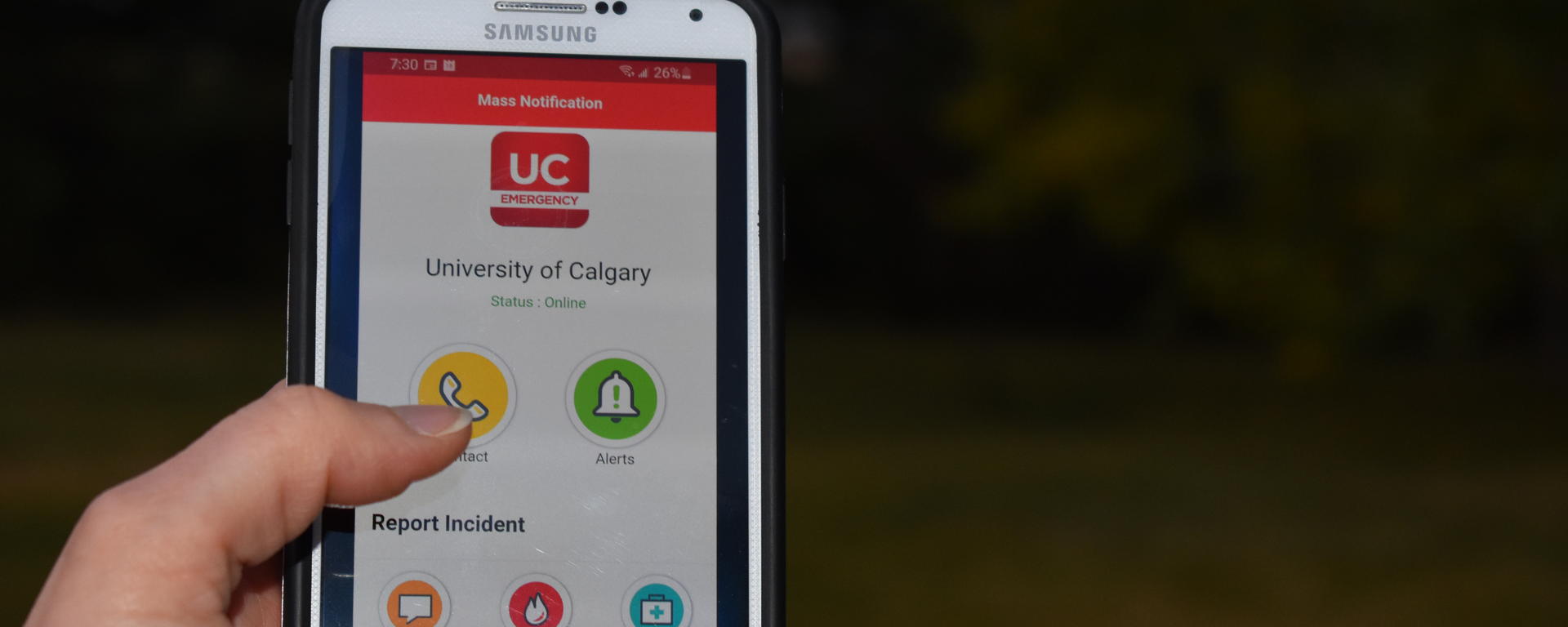 Hand holding phone with UC Emergency Mobile app open