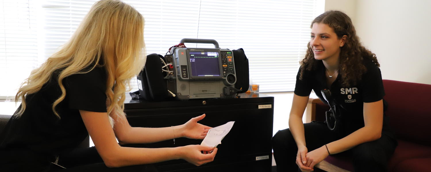 two student medical response volunteers monitor equipment in the PASS room