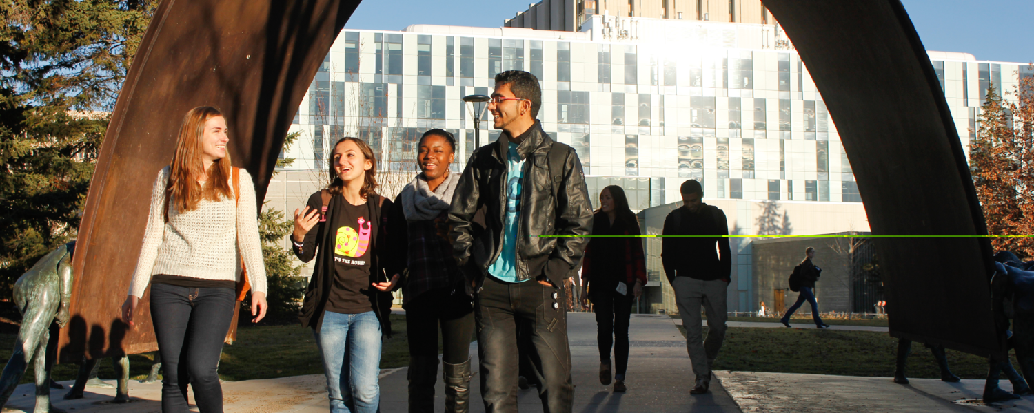 Image of four students talking with each other under a bridge at UCalgary
