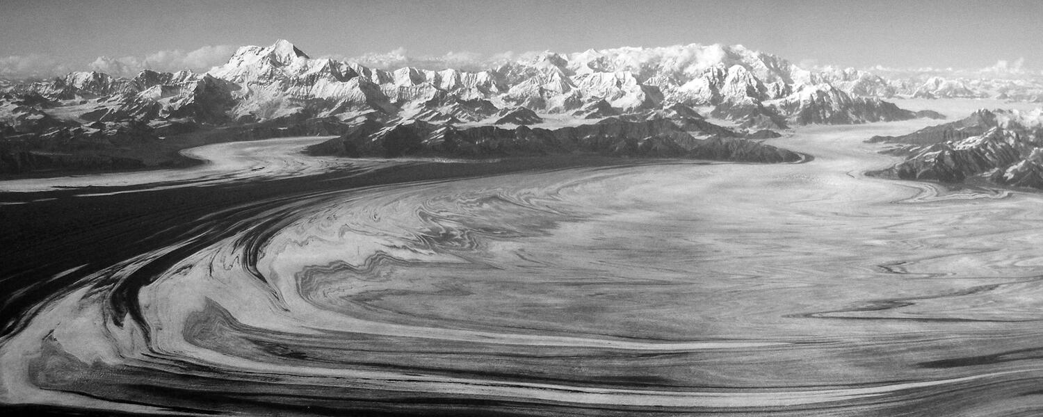 Lateral moraines and ice deform to produce finely banded and contorted patterns on the surface of the Malaspina Glacier, Alaska