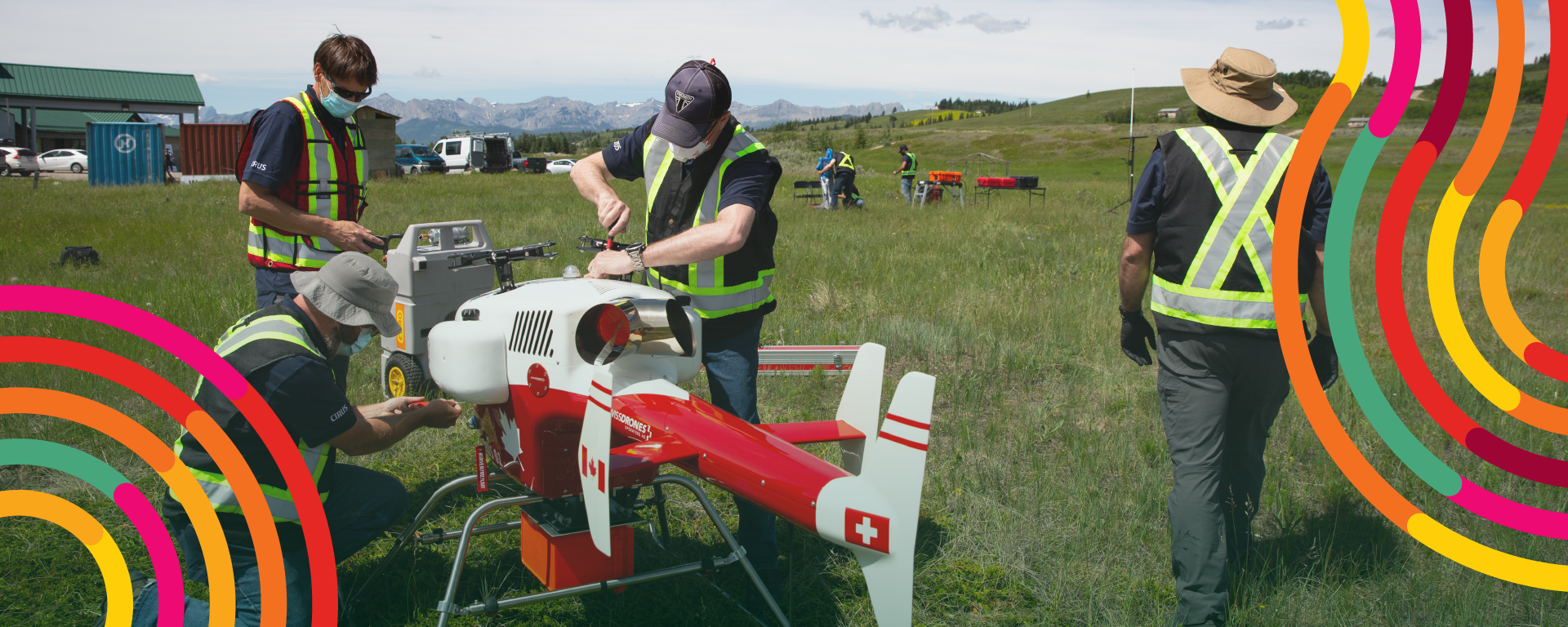 Photo of four people working in the field with a drone that delivers medical supplies