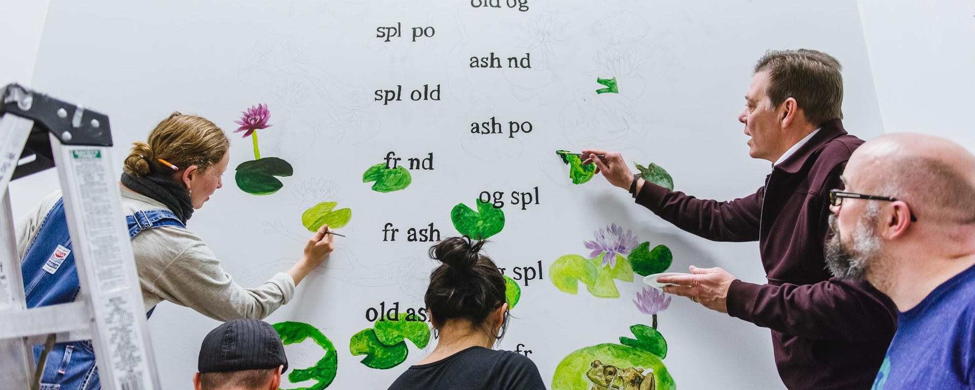 art students and faculty painting mural