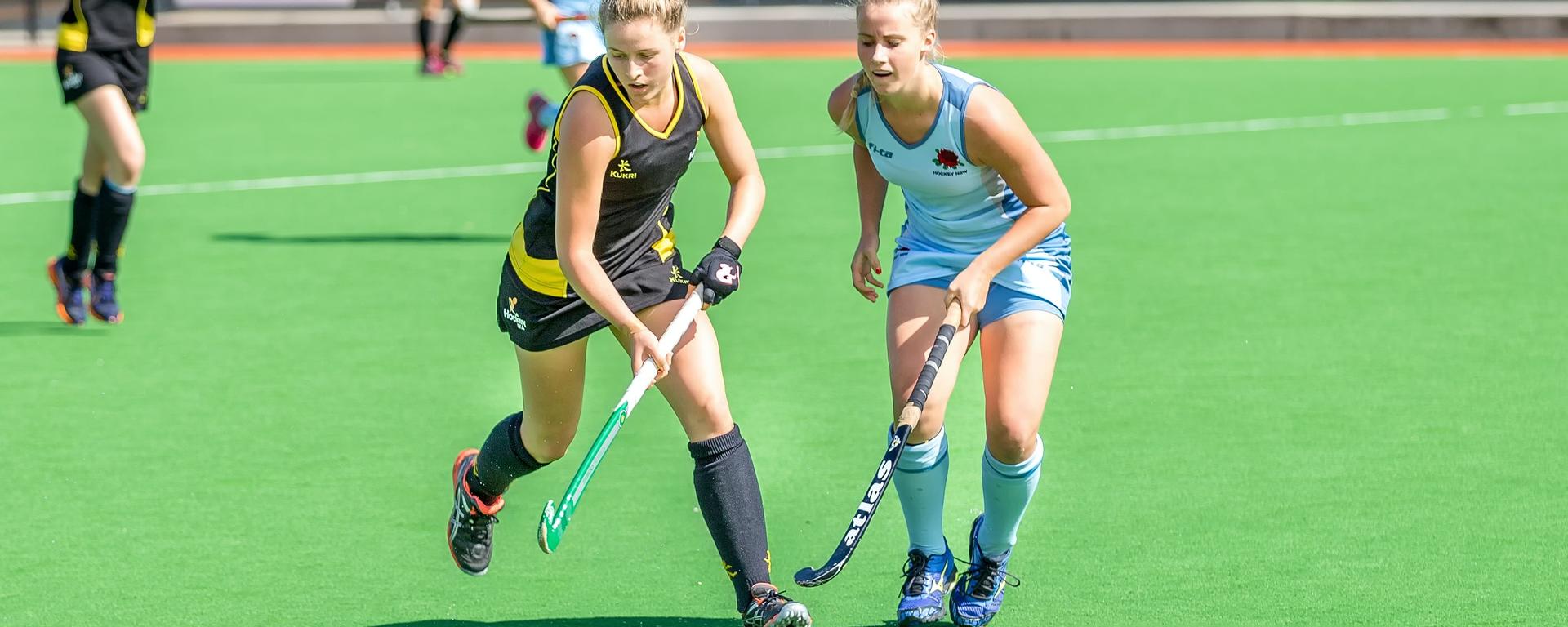 Field hockey players chasing the ball