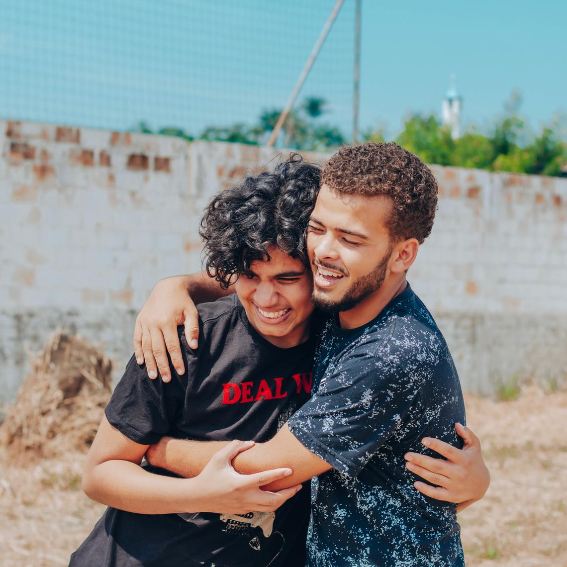 Two young men hugging