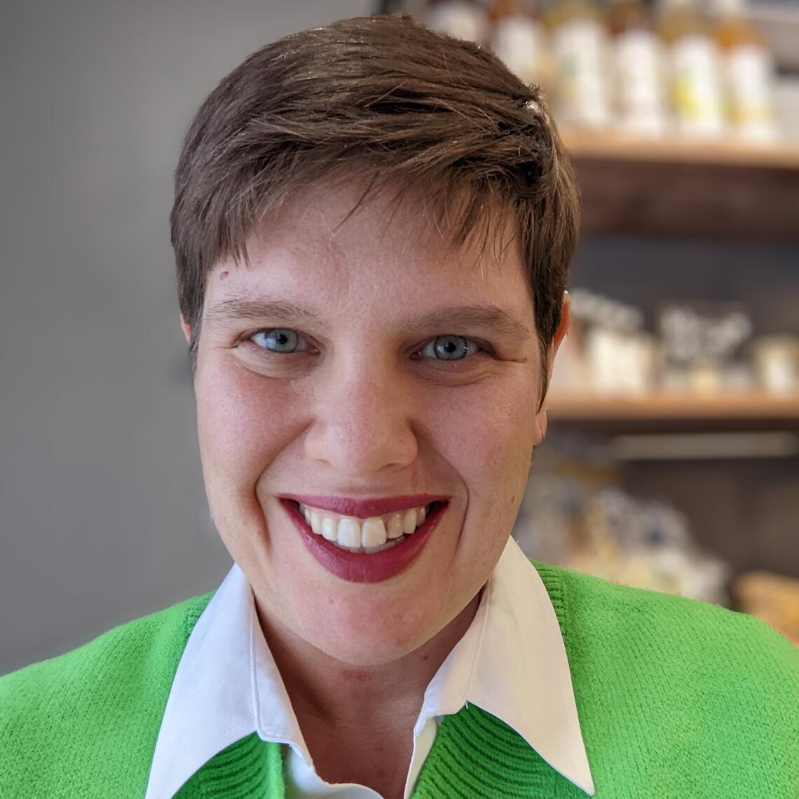 woman with short brown hair in green sweater