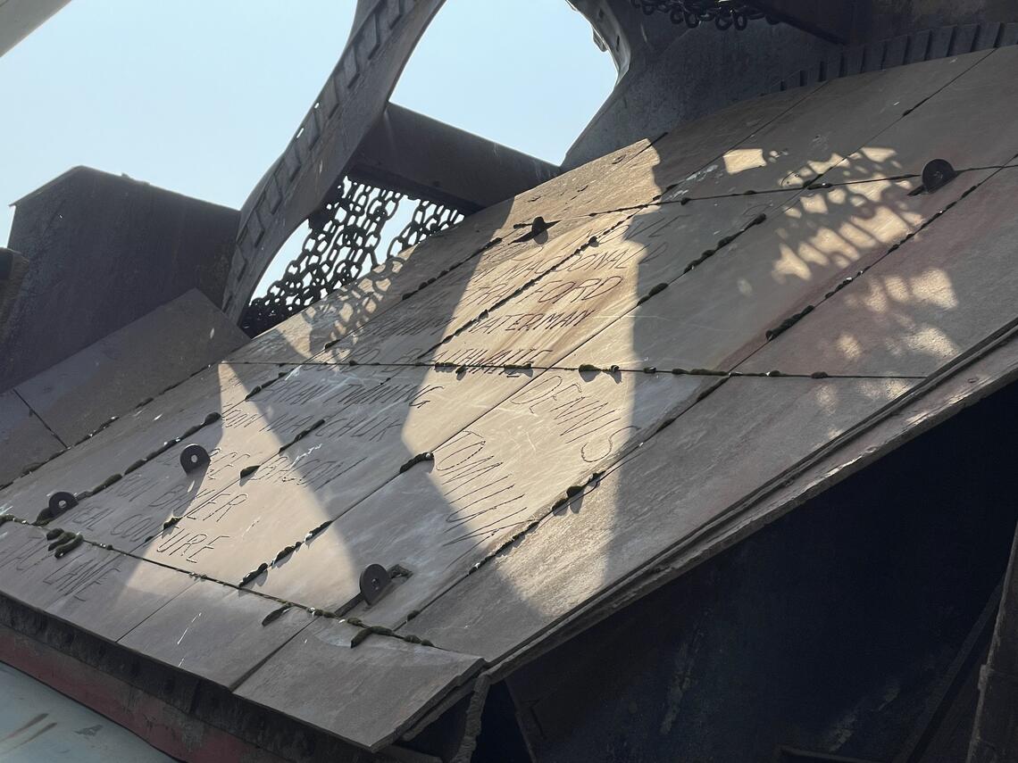 signatures welded into a rusty metal surface, part of a bucketwheel excavator