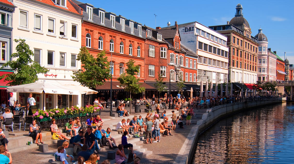 Image of pedestrians sitting alongside Aarhus canal