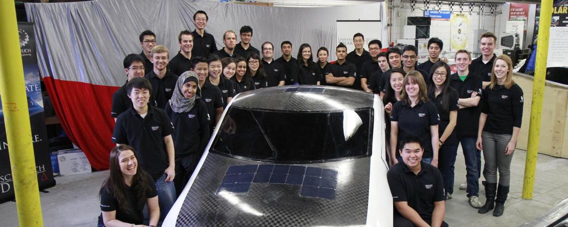 Students pose with solar car