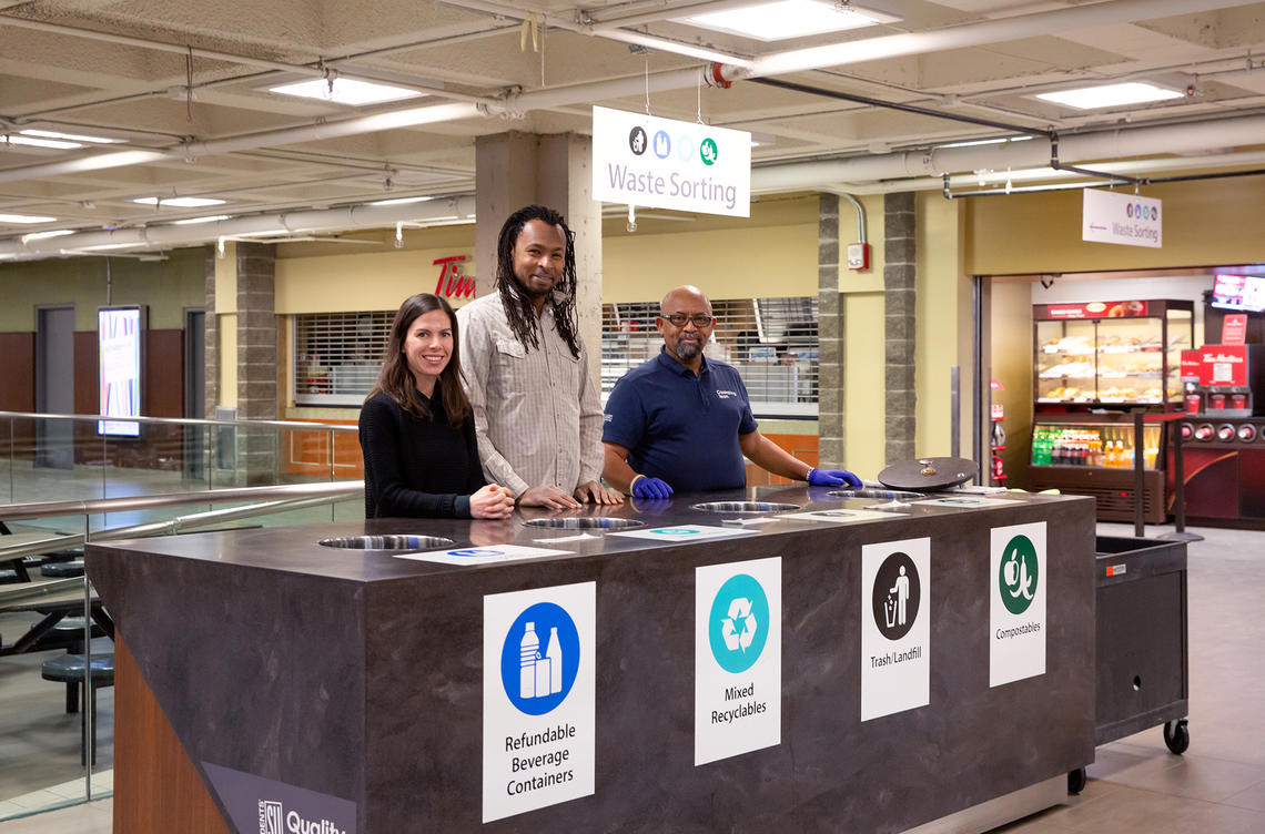 People standing at waste sorting station in MacEwan Hall