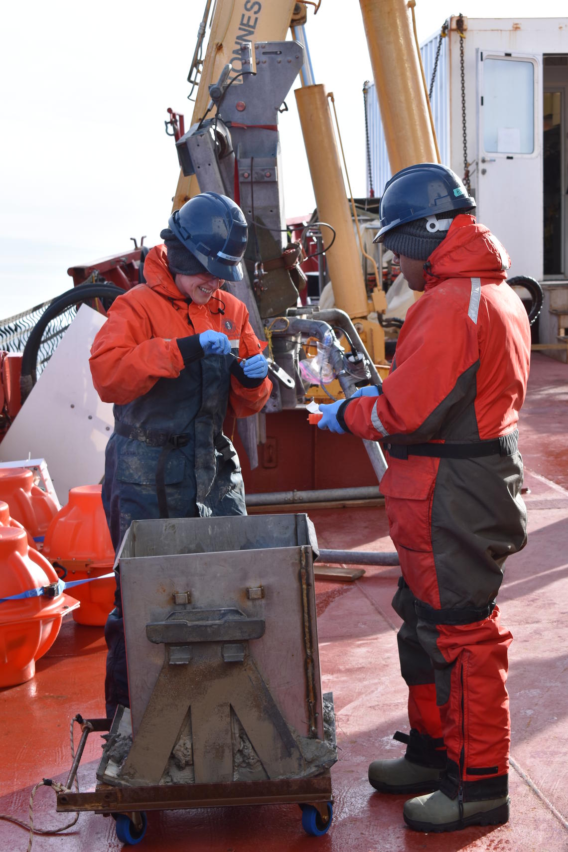 Margaret Anne Cramm and Anirban Chakraborty unpacking a boxcore on an expedition to the Arctic on the Amundsen.