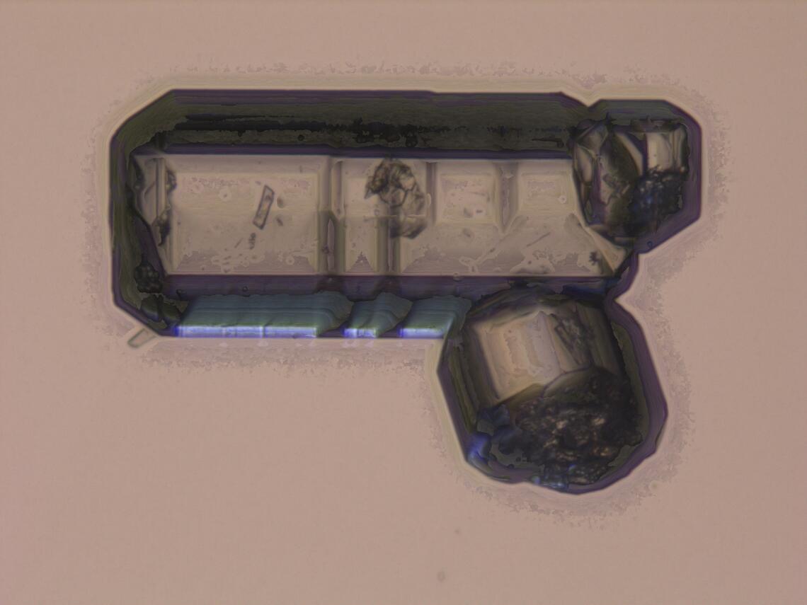 A twinned apatite grain that looks vaguely like a balloon animal made out of prismatic balloons.