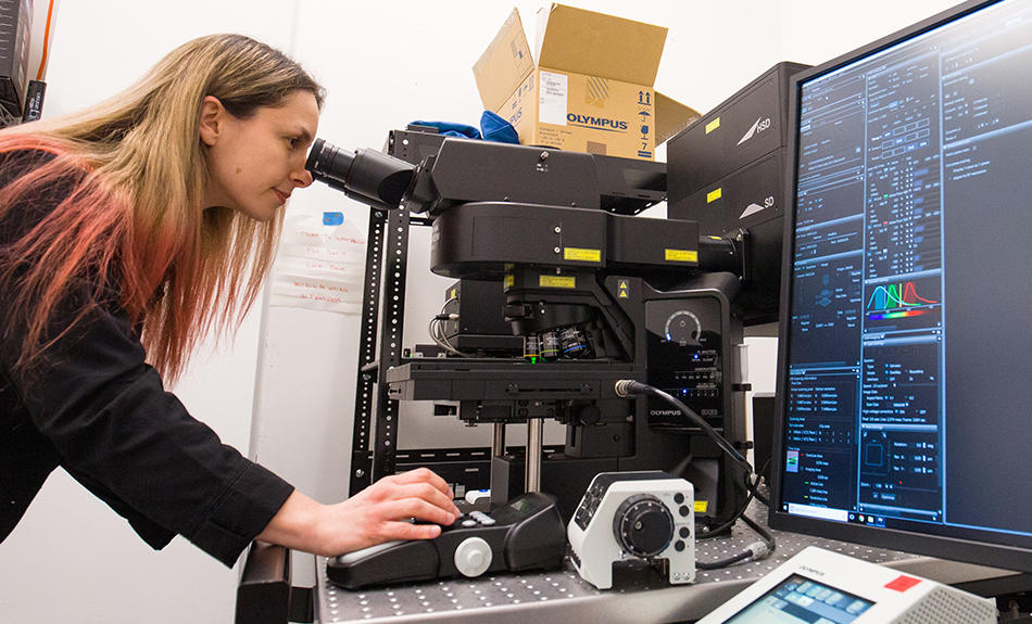 A woman looking through a microscope.