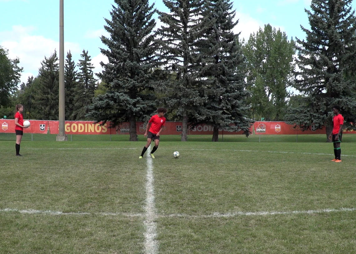 Soccer players performing cut back after receiving overhead toss
